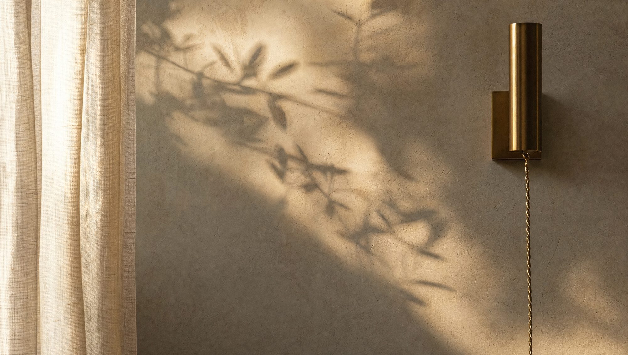 Olive-leaf shadows across a warm plaster wall beside a brass sconce